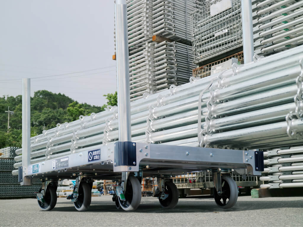 倉庫内で、作業員が赤い台車を使って荷物を運搬している様子。